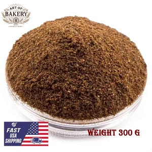 May include: A close-up of a brown powder in a clear glass bowl. The bowl is sitting on a white surface. The text "WEIGHT 300 G" is visible in the lower right corner of the image.