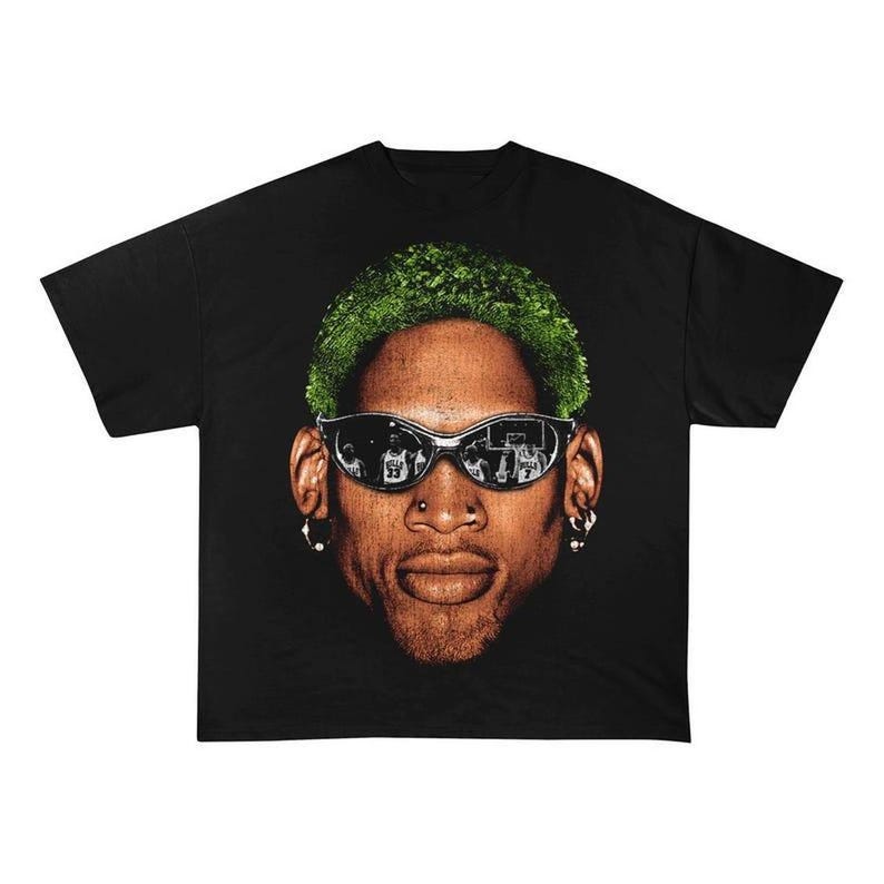May include: Black t-shirt with a graphic of a basketball player with green hair wearing sunglasses. The player is looking directly at the camera.