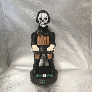 K&ouml;nnte beinhalten: Figur eines Charakters aus dem Videospiel Call of Duty: Modern Warfare. Die Figur tr&auml;gt eine schwarze taktische Kleidung mit einer Totenkopfmaske und einen Sockel mit der Aufschrift "MWII". Die Figur ist etwa 15 cm gro&szlig;.