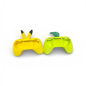 May include: Two yellow and green game controller shells. One is yellow with black pointed ears, the other is green with a green leaf. Both have a curved ergonomic design and are made of plastic.