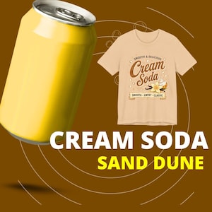 May include: A bright yellow aluminum soda can positioned next to a beige t-shirt featuring a graphic print that reads "Smooth & Delicious Cream Soda" with an illustration of a vanilla flower and whipped cream, plus the text "Cream Soda Sand Dune".