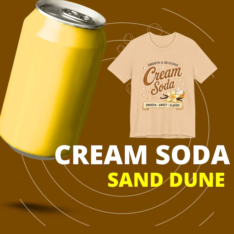 May include: A bright yellow aluminum soda can positioned next to a beige t-shirt featuring a graphic print that reads "Smooth & Delicious Cream Soda" with an illustration of a vanilla flower and whipped cream, plus the text "Cream Soda Sand Dune".