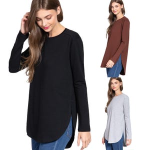 May include: Three long-sleeved shirts with side slits. The shirts are in black, brown, and gray.