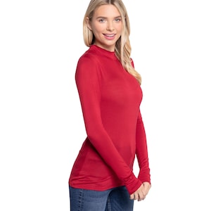 May include: A red long-sleeved mock neck shirt with a fitted silhouette.