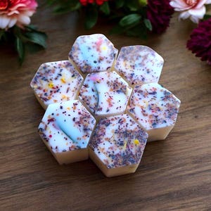 May include: A set of six hexagonal wax melts arranged in a honeycomb pattern. The wax melts are white with a variety of colourful flecks and specks.