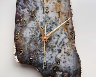 May include: A unique clock with gold hands and numbers set into a natural agate slice. The agate is a mix of brown, white, and gray with a mottled pattern.