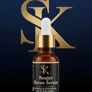 May include: A brown glass bottle of Boujee Botox Serum with a gold cap and white dropper. The label is black with gold text and the SK logo. The background is a dark blue with a gold SK logo.