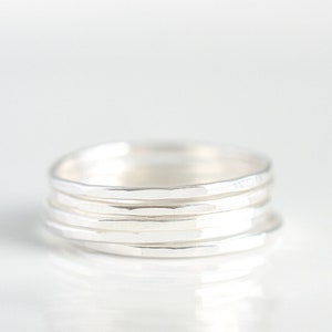 Puede incluir: Un conjunto de cinco anillos apilables de plata. Los anillos son martillados y tienen un acabado texturizado.