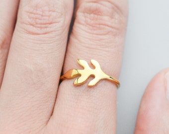 May include: A gold leaf ring with a delicate design. The ring is worn on a finger.