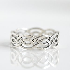 May include: A silver ring with a Celtic knot design.