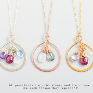 Könnte beinhalten: Drei zarte Halsketten mit runden Anhängern, die mit verschiedenen Edelsteinen besetzt sind. Jeder Anhänger hat drei kleine Edelsteine, die mit Draht umwickelt sind, darunter Amethyst, Aquamarin, Mondstein und Rubin.