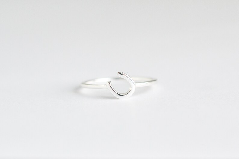 Puede incluir: Un anillo de plata con un dise&ntilde;o de herradura.