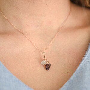 Puede incluir: Un delicado collar de oro rosa con un peque&ntilde;o colgante de piedra bruta blanca y un peque&ntilde;o colgante de piedra bruta roja.