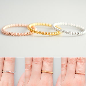 K&ouml;nnte beinhalten: Drei Perlenringe in Gold, Ros&eacute;gold und Silber. Die Ringe sind &uuml;bereinander gestapelt.
