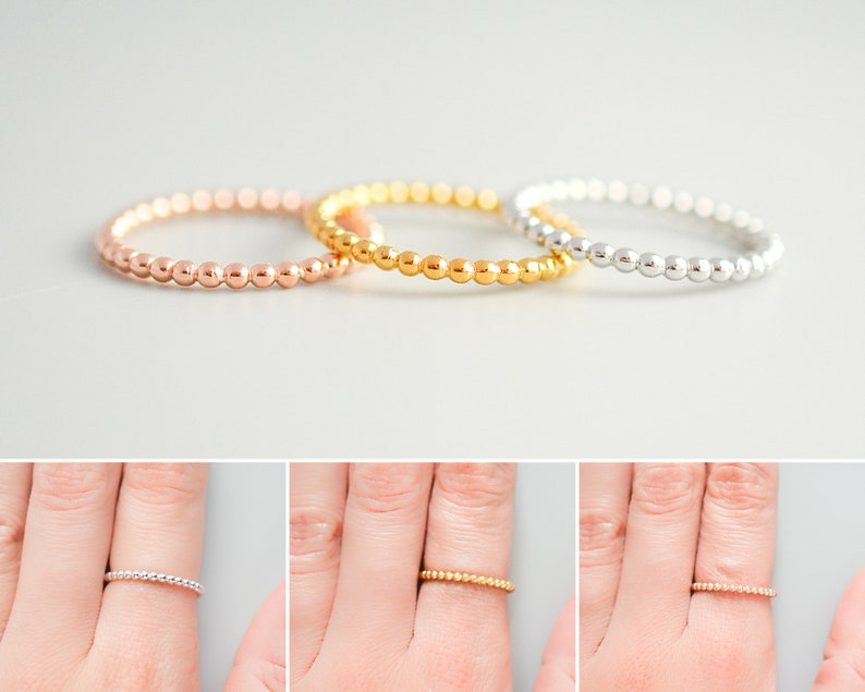 K&ouml;nnte beinhalten: Drei Perlenringe in Gold, Ros&eacute;gold und Silber. Die Ringe sind &uuml;bereinander gestapelt.