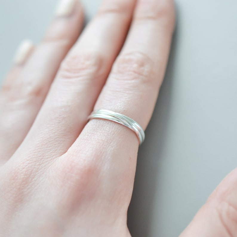 Pu&ograve; includere: Un anello d'argento con un design attorcigliato. L'anello &egrave; realizzato in un materiale metallico lucido e viene indossato su un dito. Il design dell'anello presenta pi&ugrave; fili che si intrecciano, creando un aspetto unico ed elegante. L'anello &egrave; un gioiello.