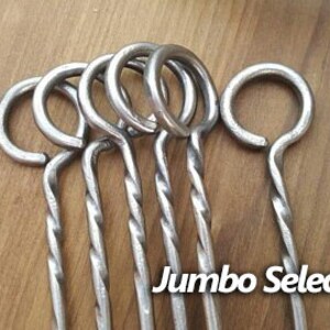 May include: Six silver metal skewers with twisted handles and a loop at the top. The skewers are labeled "Jumbo Select".