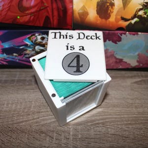 May include: White box with a lid that says "This Deck is a 4". The box is filled with teal colored cards.