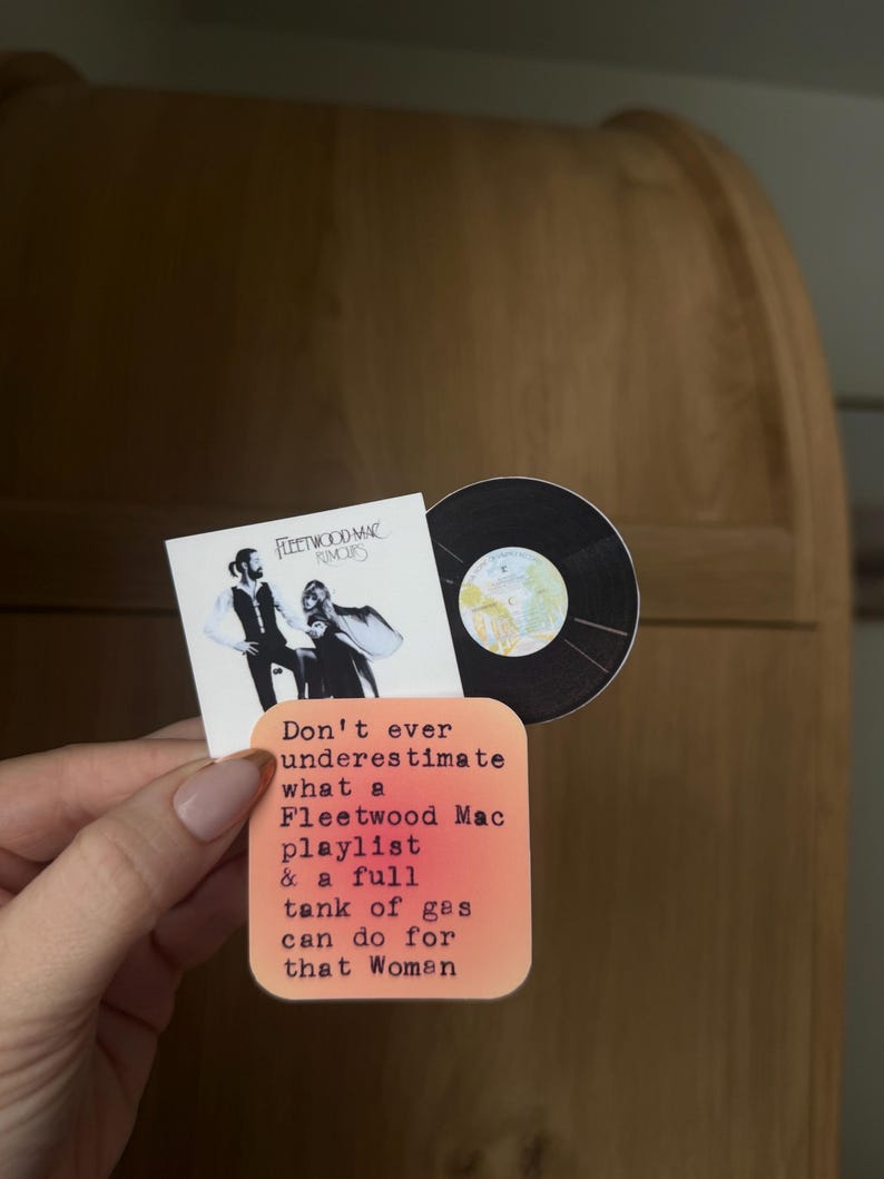 May include: A collection of stickers featuring Fleetwood Mac's "Rumours" album cover and a vinyl record. One sticker has the text: "Don't ever underestimate what a Fleetwood Mac playlist & a full tank of gas can do for that Woman."