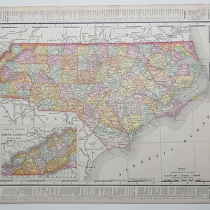 May include: A vintage map of North Carolina, showing the state's counties and major cities. The map is printed in a variety of colors, including red, yellow, green, and blue. The map also includes a smaller inset map of the western portion of the state.