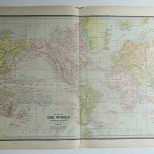 May include: A vintage world map printed on paper with a grid pattern. The map is in shades of pink, yellow, and green. The map is titled "Chart of The World" and includes the text "on Mercator's Projection" and "Copyright 1900 by Rand McNally & Co."