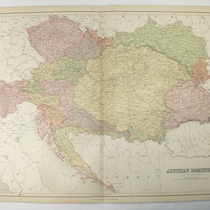 May include: A vintage map of the Austrian Dominions, showing the various provinces and territories of the Austro-Hungarian Empire. The map is printed in black and white with colored borders for each region. The map is titled "Austrian Dominions" and includes a key to the different regions.
