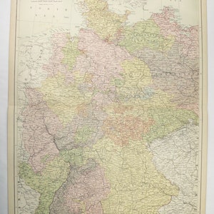 May include: A vintage map of the German Empire, showing the various states and provinces that made up the country in the late 19th century. The map is printed in black and white with colored borders for each state. The map is titled "German Empire, West Sheet" and includes a key to the different states.