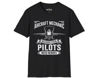 May include: Black t-shirt with a white graphic featuring an aircraft and the text "AIRCRAFT MECHANIC BECAUSE EVEN PILOTS NEED HEROES". The shirt has a crew neck and short sleeves. The brand name "SKYETCHED" is printed at the top.