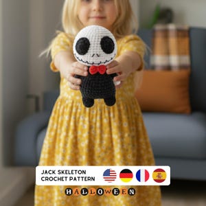 Op de afbeelding: Een gehaakte Jack Skellington-pop met een witte kop, zwarte ogen en een kleine rode vlinderdas. De pop heeft een zwart lichaam. De tekst "Jack Skeleton Crochet Pattern" en "Halloween" zijn zichtbaar.