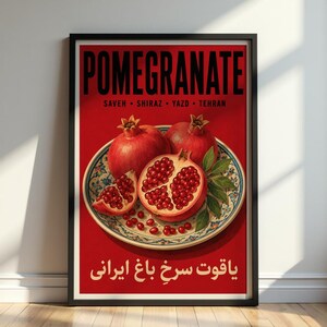 May include: A framed vertical poster with a red background featuring the text POMEGRANATE, SAVEH, SHIRAZ, YAZD, TEHRAN, and Persian script. A decorative plate holds whole and halved pomegranates with visible red seeds and green leaves.