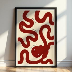 May include: A framed art print featuring a red octopus design with the words "Absolutely Nothing Is Under Control" in a black frame. The octopus has a whimsical design with a cream-colored background.