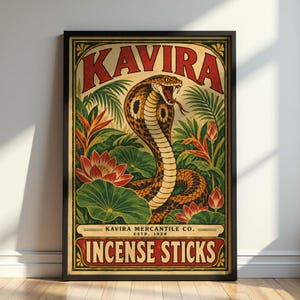 Könnte beinhalten: Ein gerahmtes rechteckiges Poster mit einer zentralen Illustration einer Kobra mit gespreiztem Nackenschild, umgeben von grünem tropischem Blattwerk und roten Lotusblüten. Der Text KAVIRA steht oben, mit KAVIRA MERCANTILE CO. ESTD. 1928 und INCENSE STICKS darunter.