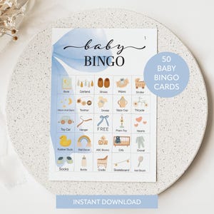 May include: Baby Bingo card with a blue watercolour design. The card features illustrations of baby-related items like a stroller, shoes, and a rubber duck. The text "baby BINGO" is at the top, with "50 BABY BINGO CARDS" in a circle.