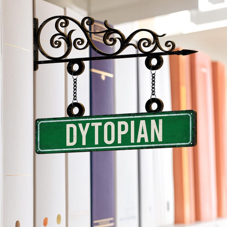 May include: A green and white "DYSTOPIAN" street sign hangs from a decorative black metal bracket. The sign is suspended by chains and set against a backdrop of books.
