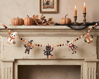 May include: A Halloween garland featuring alternating black, white, and orange felt balls strung together with five hanging wooden cutouts. The cutouts depict a ghost, a pumpkin-headed figure, a black cat, a skeleton, and an owl in vintage style.