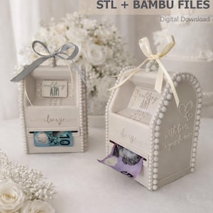 May include: Two off-white wedding ATM boxes with ribbon bows, one with a grey bow and the other with a cream bow. The boxes have the words "wedding ATM" and "always" on them. One box has a ten-dollar bill, and the other has a five-dollar bill.