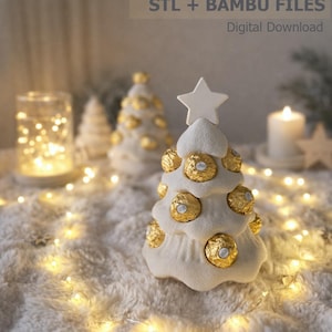 Peut inclure: Un arbre porte-chocolats blanc en forme de cône à étages, surmonté d'une étoile, avec des cavités circulaires contenant des chocolats ronds emballés dans du papier doré. Le texte indique : chocolate holder tree STL + BAMBU FILES.