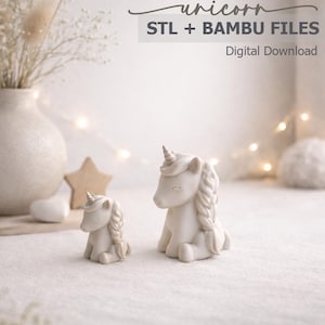 May include: Two white unicorn figurines, one large and one small, sit side-by-side. The larger unicorn has a braided mane and a horn. The image includes text that reads "unicorn STL + BAMBU FILES Digital Download".