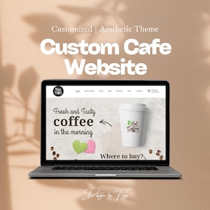 May include: A laptop computer displaying a website for a cafe. The website features a coffee cup with the text "Hot Coffee" and the words "Fresh and Tasty coffee in the morning". The website also includes a heart-shaped design and the text "Where to buy?"