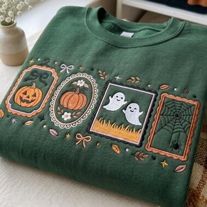 Peut inclure: Un sweat-shirt à col rond vert forêt orné de quatre écussons brodés rectangulaires. Les motifs incluent une citrouille d'Halloween, une citrouille fleurie, deux fantômes blancs sur de l'herbe et une toile d'araignée, agrémentés de petits nœuds.