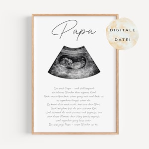 Op de afbeelding: Een ingelijste print met het woord "Papa" in cursief boven een echografiebeeld van een foetus. De print bevat Duitse tekst en een digitale bestandssticker.