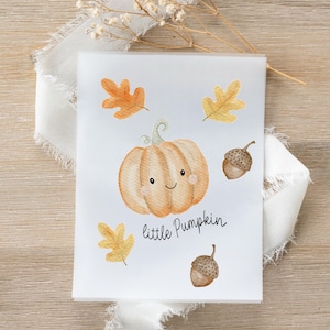 Puede incluir: Una tarjeta blanca con una ilustración de acuarela de una calabaza sonriente y el texto "little Pumpkin". La tarjeta también incluye ilustraciones de bellotas y hojas de otoño en naranja y amarillo.