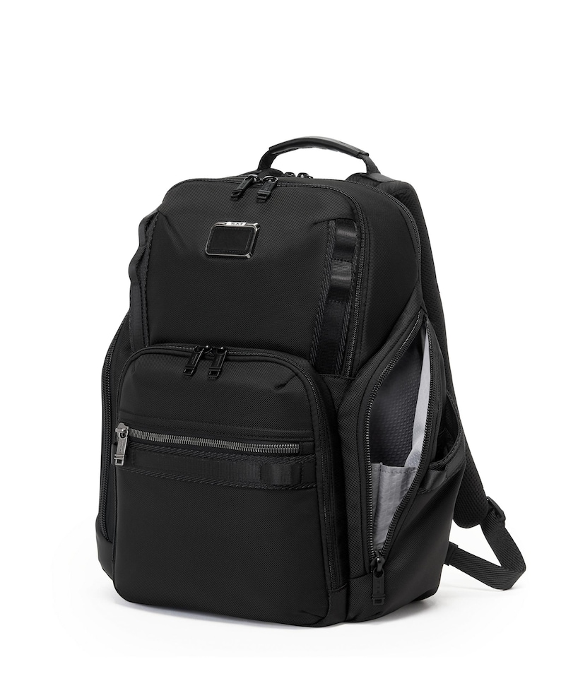 May include: Black backpack with multiple zippered compartments and a top handle. Features a small metal logo tag and a side pocket with a visible interior. The bag has adjustable shoulder straps and a sleek, modern design.