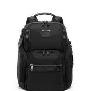 May include: Black backpack with multiple compartments and zippers. Features a top handle, padded shoulder straps, and a small metal logo tag. The bag has a sleek, modern design, suitable for travel or everyday use.