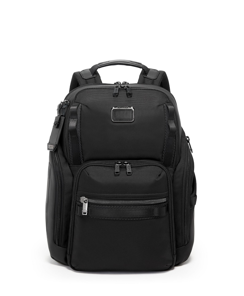 May include: Black backpack with multiple compartments and zippers. Features a top handle, padded shoulder straps, and a small metal logo tag. The bag has a sleek, modern design, suitable for travel or everyday use.