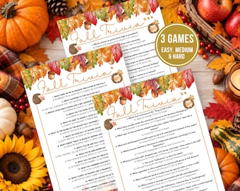 May include: Three printed game sheets titled Fall Trivia featuring a border of colourful autumn leaves, acorns, and small woodland animals. Each sheet contains multiple-choice questions about fall themes, with a gold circular badge stating 3 GAMES EASY, MEDIUM & HARD.
