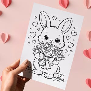 May include: A black and white illustration of a cute bunny holding a bouquet of roses, with hearts and stars around it. The image is on a white paper, with pink paper hearts on a pink background.