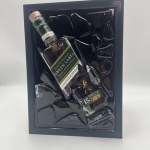 May include: Framed artwork featuring a Johnnie Walker Green Label whisky bottle. The bottle is set against a black background with abstract glass-like shapes. The label reads "Green Label Blended Malt Scotch Whisky".