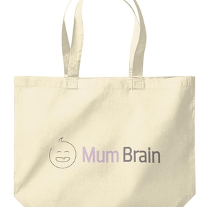 Può includere: Borsa tote color crema con due manici. La borsa presenta un volto sorridente di un cartone animato con le parole "Mum Brain" in testo viola e grigio. La borsa è realizzata in un tessuto morbido e resistente.