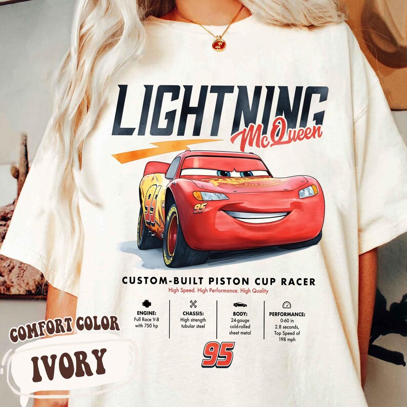 Puede incluir: Camiseta marfil Comfort Color con Lightning McQueen de la pel&iacute;cula Cars. El dise&ntilde;o incluye el texto "LIGHTNING McQueen" y "CUSTOM-BUILT PISTON CUP RACER". Tambi&eacute;n incluye especificaciones t&eacute;cnicas del coche.